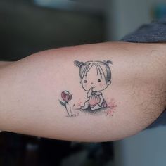 a small tattoo on the arm of a girl with a flower in front of her