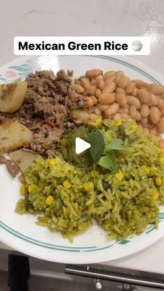 mexican green rice on a plate with beans and other foods in front of the camera