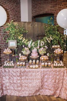 a table topped with lots of cupcakes and cakes