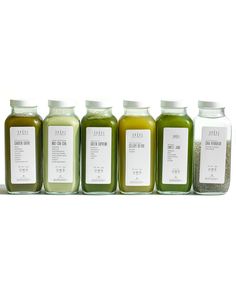 six bottles of green juice lined up in a row