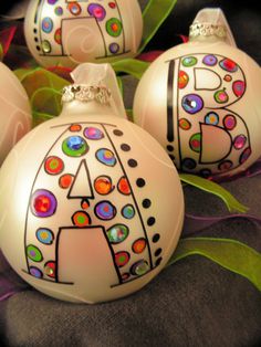 three white ornaments with designs on them sitting on a table