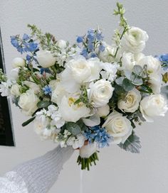 a bouquet of white and blue flowers in a vase