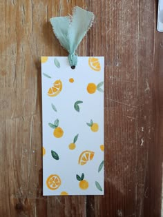 a piece of paper with oranges on it hanging from a wooden wall next to scissors