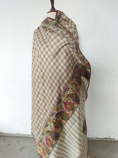 > Semi pashmina, a mix of pure Kashmiri wool and pashmina woven to make the fabric of this shawl > Plain cheque shawl with patch stitched on it > Hand painted and embroidered woollen patch is handstitched over this shawl > Embroidery is in outline > Traditional Kashmiri shawl designs of paisleys, flowers and motifs have been used in these patches > These are patchwork shawls only available at Kashmina > On request, patch can be stitched to any base color of the shawl Luxury Multicolor Katan Silk Pashmina Shawl, Luxury Beige Pashmina Shawl With Dupatta, Beige Pashmina Shawl In Traditional Drape, Brown Bohemian Pashmina Dupatta, Bohemian Beige Pashmina Shawl Dupatta, Beige Bohemian Pashmina Shawl, Patchwork Shawl, Shawl Embroidery, Kashmiri Shawls