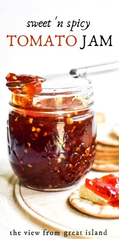 a glass jar filled with jam next to crackers