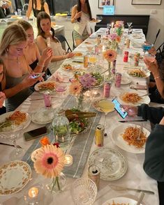 a group of women sitting at a table with plates of food in front of them