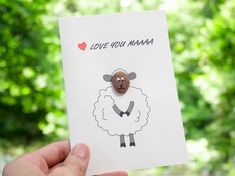 someone holding up a card with a sheep on it and the words love you mama