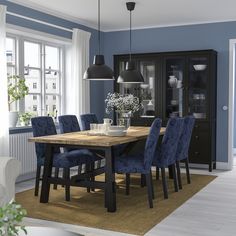 a dining room with blue chairs and a wooden table