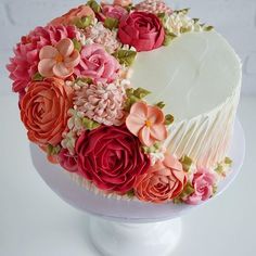 a white cake with pink and red flowers on it