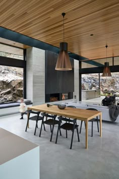 a dining room table and chairs in front of a large window with an open fireplace