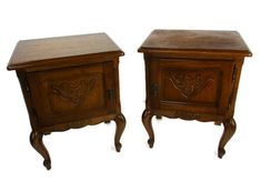 two wooden nightstands with carved designs on the top and bottom, sitting side by side