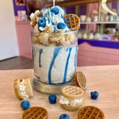 an ice cream sundae with waffles, blueberries and whipped cream on top