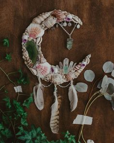 an assortment of seashells and sea glass on a table with greenery around it