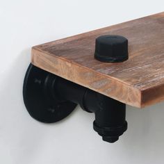 a wooden shelf with a black pipe on it