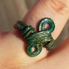 The green patina on this woven copper wire ring gives it the illusion of sunken treasure, lost beneath the sea. With a subtle infinity design, this ring is a classy, bold accompaniment to any outfit. Handmade and one of a kind, this ring would make a beautiful birthday gift for a teenager, a Valentine's Day gift for your loved one, or treat for yourself! The minimalist style makes it the perfect subtle accompaniment for any outfit at any occasion. Like what you see, but want a different size? Not a problem! Contact me for custom-made jewelry along the same lines. I'm more than happy to work up something more suited to your own personal color palette, or produce another version specifically tailored to the outfit you had in mind. Ships from Boston, Massachusetts. I ship worldwide! Earthy Green Wire Wrapped Jewelry, Minimalist Handmade Green Ring, Unique Green Copper Ring, Unique Green Copper Rings, Hand Wrapped Green Ring For Gift, Adjustable Green Bohemian Rings, Handmade Green Toe Ring, Green Wire-wrapped Rings For Jewelry Making, Green Wire Wrapped Rings For Jewelry Making