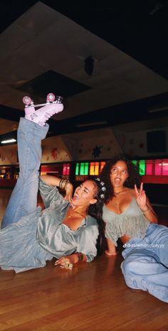 two women laying on the floor with their arms in the air while one woman holds her leg up