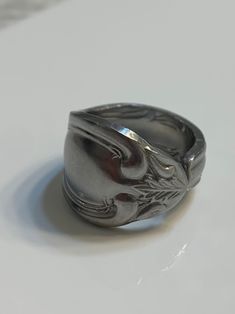 a silver ring sitting on top of a white table