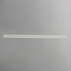 a white light hanging from the ceiling in a room with gray walls and flooring