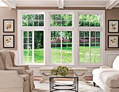 a living room filled with white furniture and lots of window panes on the wall