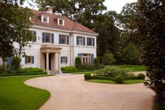 a large white house surrounded by lush green trees