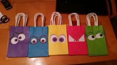 four small bags with eyes on them are sitting on a table next to a laptop