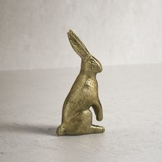 a gold colored rabbit figurine sitting on its hind legs