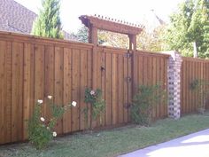 a wooden fence with flowers growing on it