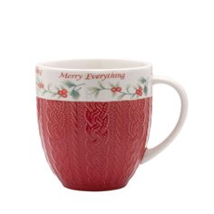 a red coffee cup sitting on top of a white tablecloth with merry everything written on it