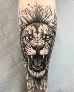 a black and white tattoo of a lion on the leg, with its mouth open