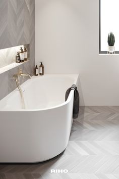 a white bath tub sitting in a bathroom next to a window with potted plants