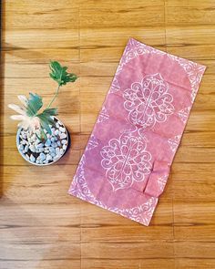 a potted plant sitting on top of a wooden floor next to a pink towel