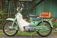 a green and white motorcycle parked next to a building