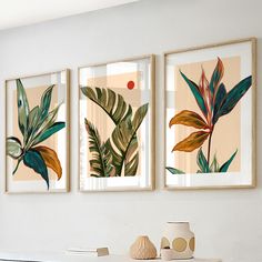 three framed art prints on the wall above a table