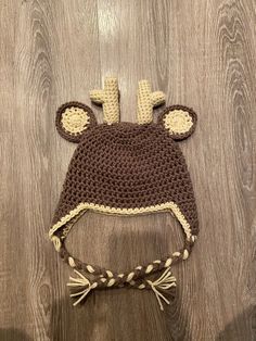 a crocheted hat with ears on top of a wooden floor