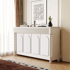 a large white cabinet sitting in the middle of a living room next to a window