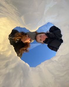 two people are standing in the snow looking up