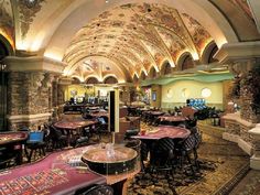 the interior of a casino with tables and chairs