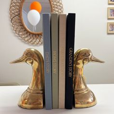 two bookends made out of books sitting on top of a white table next to each other