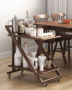 a wooden table topped with lots of cups and drinks on top of it's wheels