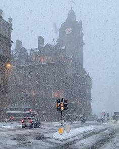 a city street is covered in snow and traffic lights