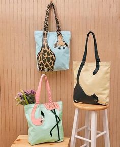 three different types of handbags hanging on a wall next to a stool with flowers