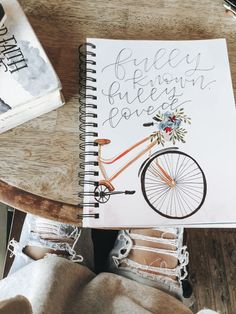 a note book with an image of a bicycle on it and the words fully written in cursive writing