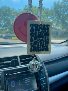 a car dashboard with a sign hanging from it's center console