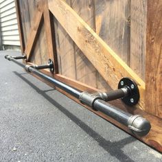 a metal pipe is attached to the side of a wooden fence