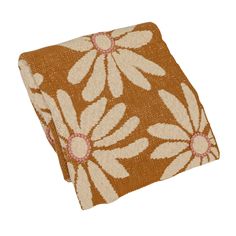 a brown and white flowered pillow on a white background