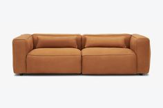 a brown couch sitting on top of a white floor