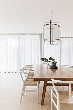 a dining room table with chairs and a light fixture hanging from the ceiling over it