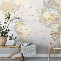 a room with a chair, potted plant and map on the wall