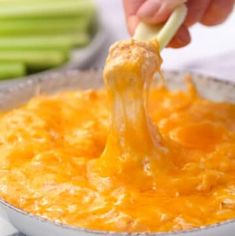 a person is dipping cheese into a bowl