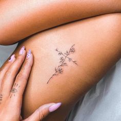 a close up of a woman's stomach with tattoos on her legs and flowers